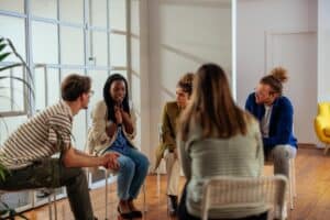a group of people sit in a circle together talking to each other in an intensive outpatient program for depression